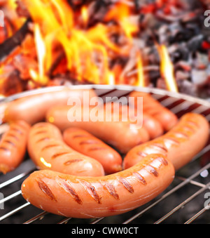 Sausages on a grill. In the background in bonfire. Stock Photo