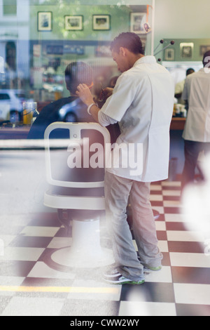 Barber working on client in shop Stock Photo