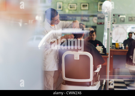 Barber working on client in shop Stock Photo