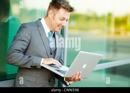 Businessman using laptop outdoors Stock Photo