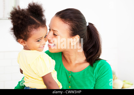 Mother and daughter hugging in kitchen Stock Photo