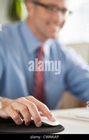 Businessman clicking mouse at desk Stock Photo
