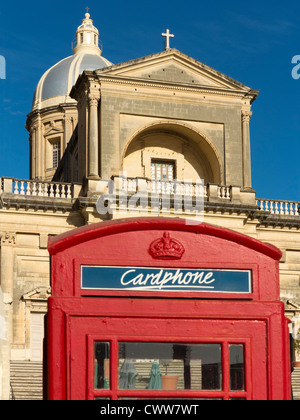 Phone box in front of the Parish church of St Joseph, Kalkara, Island of Malta, Mediterranean Sea. Stock Photo