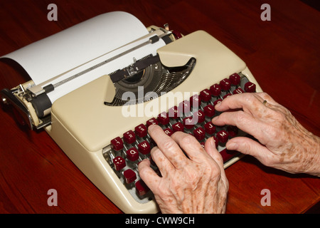 Elderly woman writes on a typewriter Stock Photo