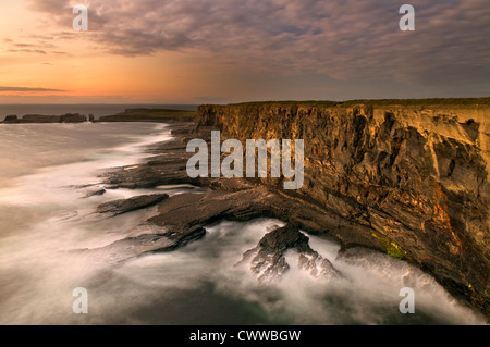 Fog rolling up to rocky coastal cliffs Stock Photo