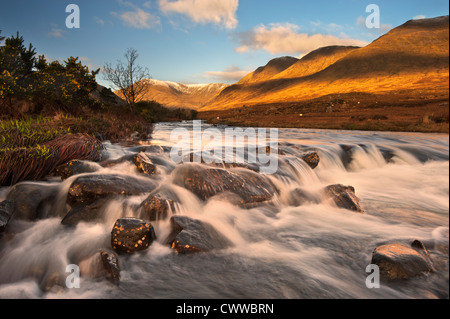 Blurred view of river rushing over rocks Stock Photo