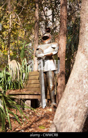 Metal suit of armor next to sitting bench in wooded area of Central Florida Stock Photo