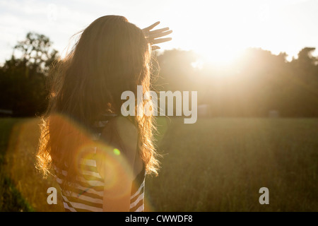 Woman shielding her eyes from sun Stock Photo