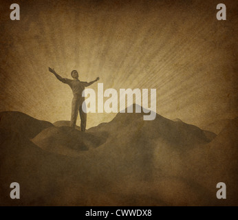 Faith and religion with old grunge paper parchment represented by a man on a mountain with his arms raised to the heavens in search of belief and spirituality. Stock Photo
