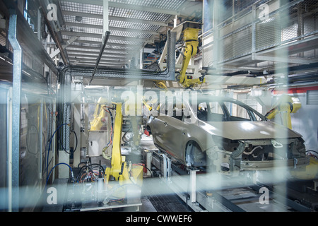 Robots applying sealant to cars in car factory