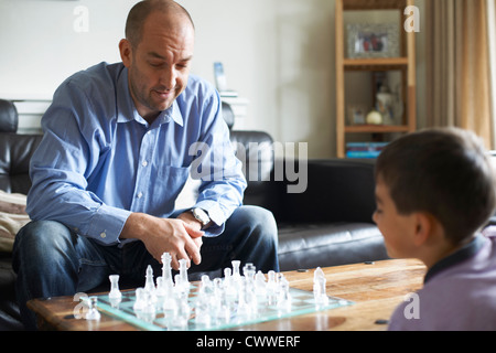 Father and son playing chess together Stock Photo