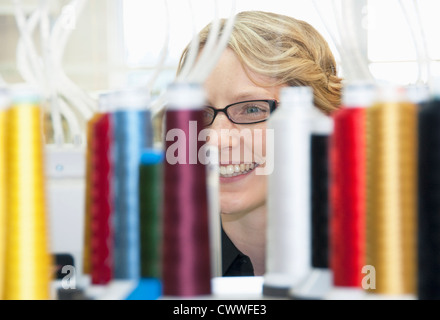 Worker examining spools of thread Stock Photo