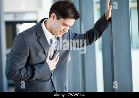 young businessman having heart attack or chest pain Stock Photo