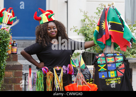 Notting Hill Carnival in London, young woman selling souvenirs in the street Stock Photo