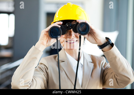 middle aged female construction project manager using binoculars Stock Photo
