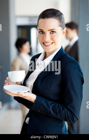 beautiful young businesswoman drinking coffee in office during break Stock Photo