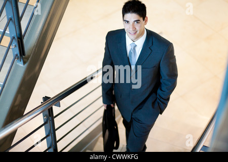 young handsome businessman walking up stairs Stock Photo