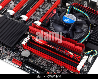 Closeup of a high-end computer motherboard ASUS Maximus V Extreme with DDR3 memory in slots and a CPU cooler fan Stock Photo
