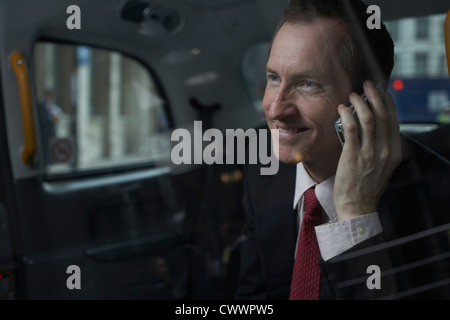 Businessman on cell phone in backseat Stock Photo