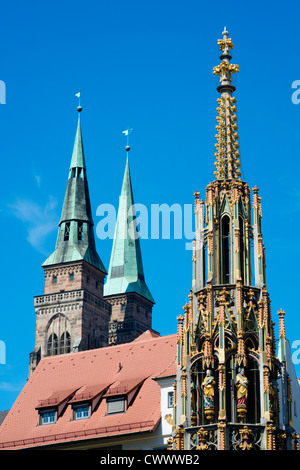 Schoene Brunnen (Beautiful Fountain) and spires of St Sebald's church in Nuremberg in Bavaria Germany Stock Photo