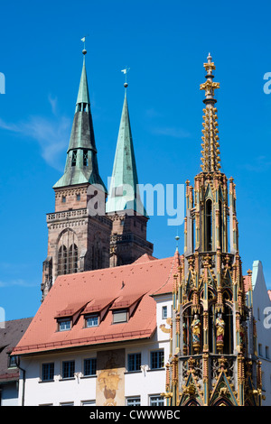 Schoene Brunnen (Beautiful Fountain) and spires of St Sebald's church in Nuremberg in Bavaria Germany Stock Photo