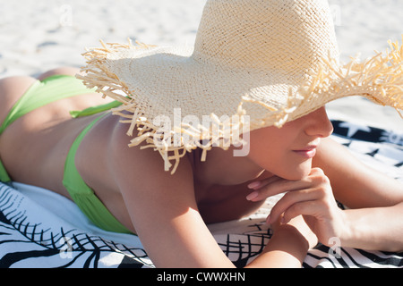 Woman wearing straw hat on beach Stock Photo