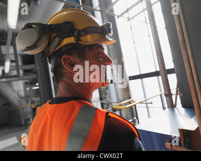 Worker wearing hard hat and headphones Stock Photo