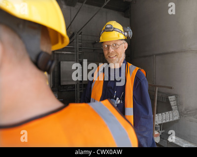 Workers talking in factory Stock Photo