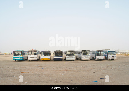 Tour buses parked in dirt lot Stock Photo