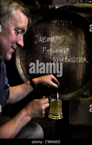 Farmer sampling cider in a farm shop on an English farm, Herefordshire, UK Stock Photo