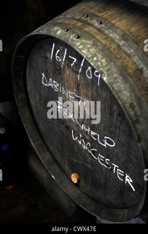 A barrel of cider with the varieties of apples used chalked on the front in a farmshop on an English farm, Herefordshire, UK Stock Photo