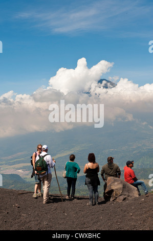 Hikers on Pacaya volcano, with Fuego Volcano in distance Antigua, Guatemala, Central America. Stock Photo