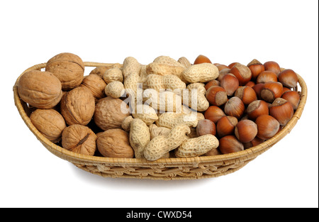 Walnuts, hazelnuts and peanuts in a wicker basket on a white background, isolated Stock Photo