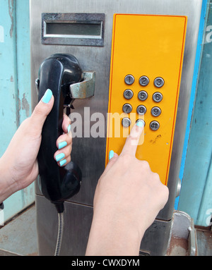 women hand dialing on a public phone Stock Photo