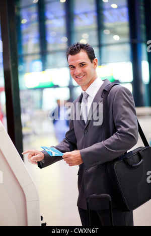 businessman using self help check in machine at airport Stock Photo