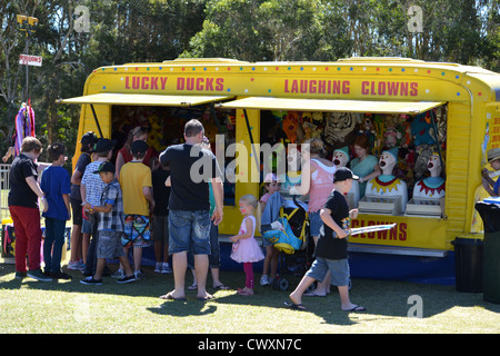 parents with their children at the laughing clowns and lucky ducks stand at a school fete / fair Stock Photo