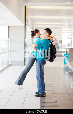 happy young couple hugging at airport Stock Photo