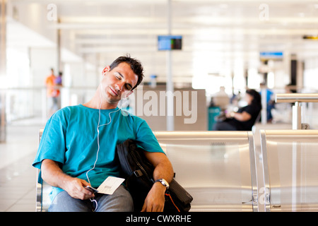tired young male traveler sleeping in airport Stock Photo