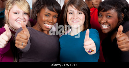 Multi-ethnic smiling women showing the thumbs up sign Stock Photo