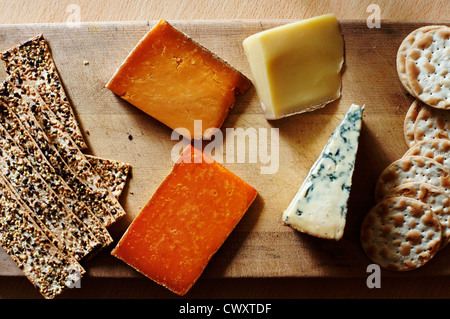 A selection of English cheeses with crackers on a cheese board. Stock Photo