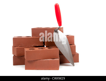 Stacks of red bricks and a trowel on a white background Stock Photo