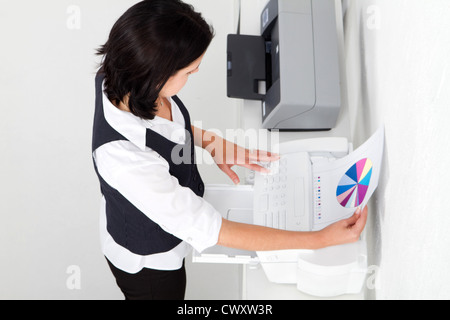 businesswoman using fax machine in office Stock Photo