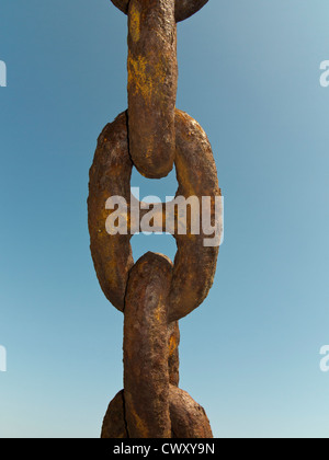Close up of large rusted anchor chain links against a blue sky Stock Photo