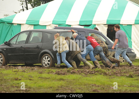 pushing a car stuck in mud Stock Photo