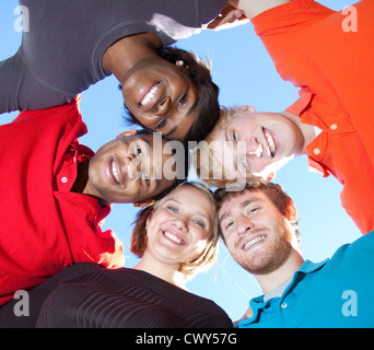 A multi-ethnic group of smiling college or high school friends or students making a huddle Stock Photo
