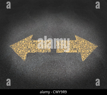 Strategy and decisions concept with a textured asphalt road and two old painted yellow arrows pointing in opposite directions as a business symbol of confusion and uncertainty in the future path ahead. Stock Photo