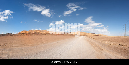 Road in the desert towards the distant rocks Stock Photo
