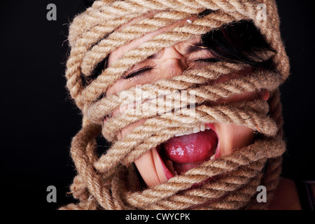 Tied up woman screaming. Violence concept. Stock Photo