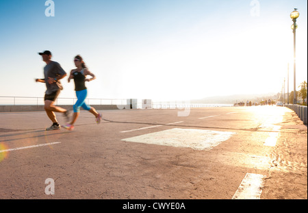 Man and woman running on the promenade at the seaside. Motion blur on the runners, a lot of copy space (Nice, France, Europe). Stock Photo