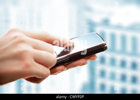Closeup of female hands using a smart phone. City background. Stock Photo